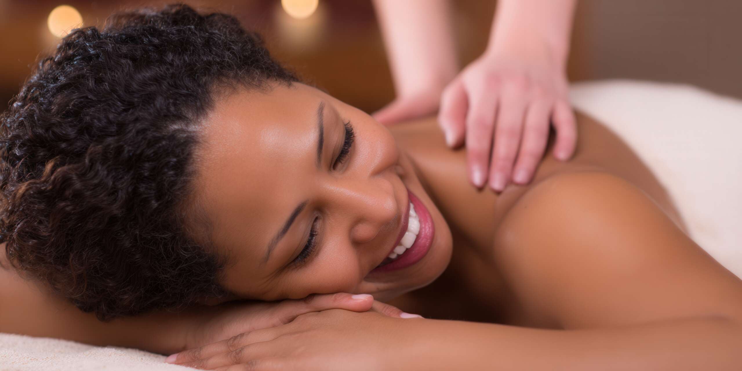 A beautiful woman enjoys a shoulder massage at a relaxing spa setting.